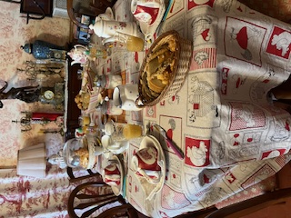 Table du petit-déjeuner dressée : viennoiseries dans une corbeille, jus d'orange, vaisselle à motifs rouges