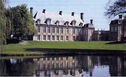 Château classique se reflétant dans un plan d'eau, entouré d'arbres